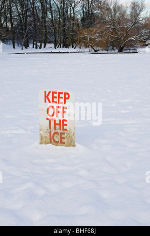 Halten Sie das Eisschild auf dem tiefgefrorenen, schneebedeckten See im Winter vom Rowntree Park York North Yorkshire England Großbritannien GB Großbritannien ab Stockfoto