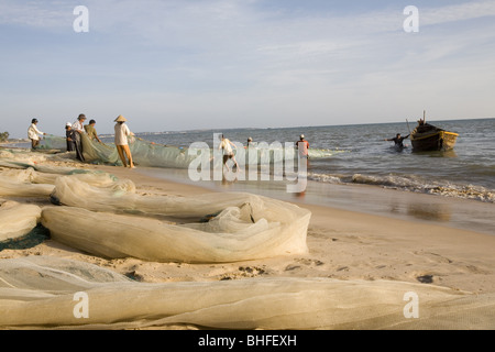 Fischer mit Fischernetz auf den Strand von Mui Ne, Provinz Binh Thuan, Vietnam, Asien Stockfoto