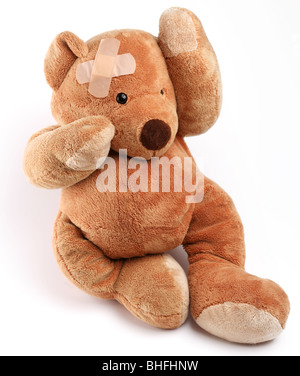 Krank Teddybär mit Gips auf den Kopf. Isoliert auf weißem Hintergrund. Stockfoto