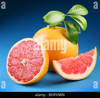 Reife Grapefruit mit Abschnitt auf blauem Hintergrund Stockfoto