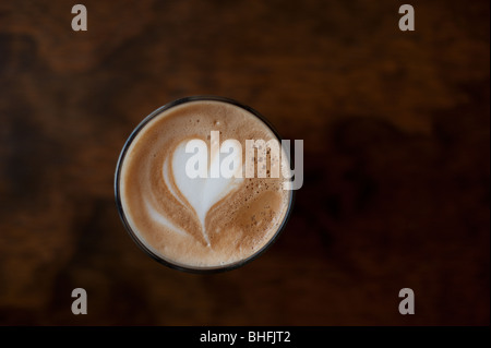 Ein Herz in "Latte Art" über einen hohen Café Latte Kaffee gezeichnet. Stockfoto