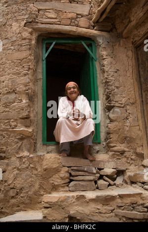 Portrait von eine alte Frau sitzt in einem Türrahmen des kreisförmigen Dorf tissraouen, Marokko, Nordafrika Stockfoto