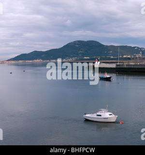 Marine mit zwei kleine Yachten und ein Berg im Hintergrund bei der Einfahrt in den Hafen von Colindres, Kantabrien, Spanien Stockfoto