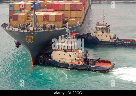 Schlepper "Svitzer Grand Bahamas" Appiles macht zum Bug des "MSC Uganda" in dem Bemühen, das Schiff aus dem Hafen zu manövrieren. Stockfoto