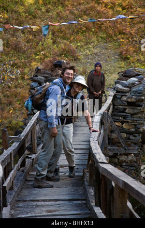 Bodhi Garrett und Christine Kolisch überqueren eine wackelige Brücke mit eine 100 Fuß-Drop off auf beiden Seiten - MANASLU Trekking, NEPAL Stockfoto