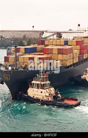 Schlepper "Svitzer Grand Bahamas" Appiles macht zum Bug des "MSC Uganda" in dem Bemühen, das Schiff aus dem Hafen zu manövrieren. Stockfoto