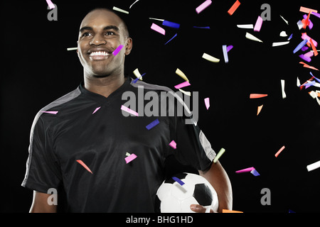 Fußballer mit fallenden Konfetti Stockfoto