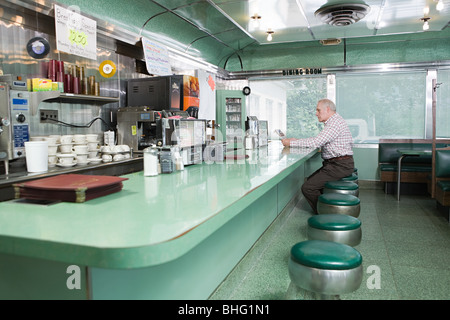 Alter Mann sitzt in einem diner Stockfoto