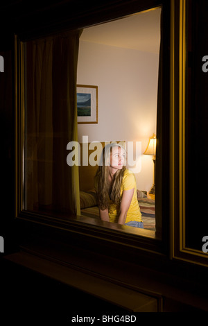 Junge Frau im Motelzimmer Stockfoto