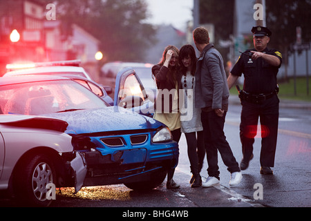 Junge Menschen und Polizeibeamten am Tatort Autounfall Stockfoto