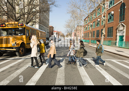 Lehrer und Schüler, die Straße überqueren Stockfoto