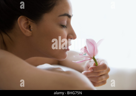 Junge Frau, die eine Orchidee Blume Stockfoto