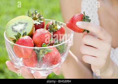 Frau mit Schale mit Erdbeeren und kiwi Stockfoto