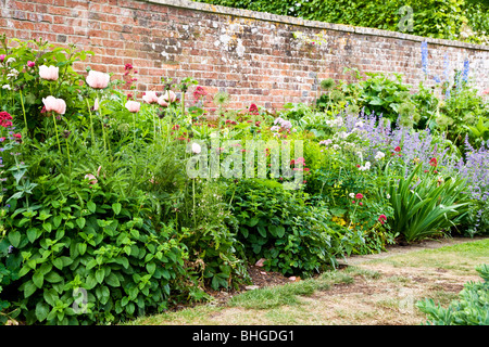 Teil eine krautige mehrjährige Blumen in einem ummauerten Garten in einen englischen Landschaftsgarten. Stockfoto