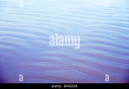 Abstrakte Ansicht eines Teils der nassen Sandstrand mit Wellen und einen kühlen blauen Himmel reflektiert Stockfoto