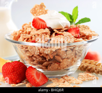 Schüssel mit Frühstücks-Cerealien, garniert mit weißen Joghurt Stockfoto