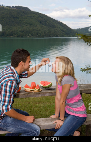 Ein junges Paar mit einem Picknick an einem See Stockfoto