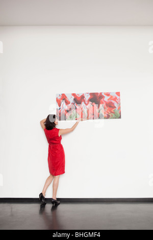 Frau, die ein Bild aufhängen Stockfoto