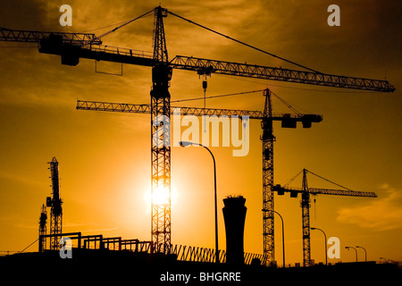 Turmdrehkrane auf einer Baustelle während des Sonnenuntergangs, Malaga, Spanien. Stockfoto