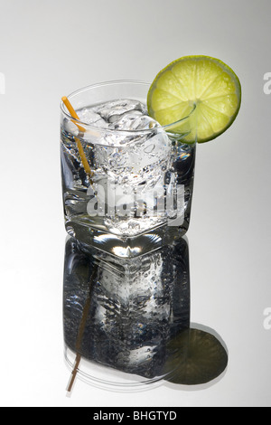 Gin oder Wodka und Club Soda oder Tonic Mixgetränk mit Kalk Schicht garnieren auf grauem Hintergrund Stockfoto