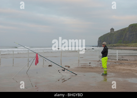 Fischer am Strand deutlich bergab frühen Abend mit Angelrute montiert auf einem Stativ warten auf einen Biss! Stockfoto