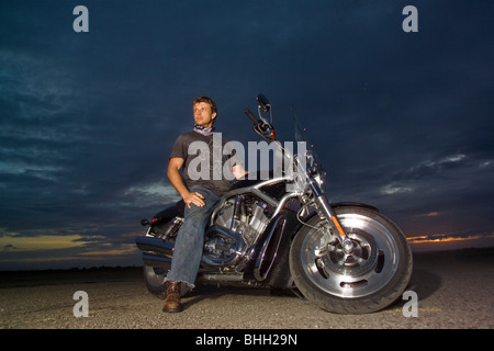 3631 Karem auf HD. Mann sitzt auf Harley-Davidson V-Rod Black Chrome bei Sonnenuntergang Stockfoto