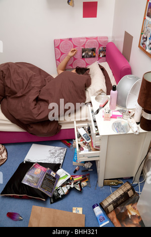 Ein junges Mädchen schlafend in ihrem chaotisch Schlafzimmer Stockfoto