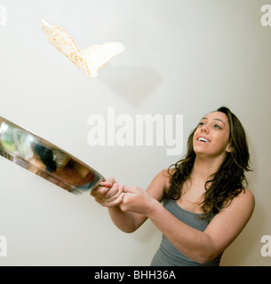 Jugendlicher warf einen Pfannkuchen in einer Pfanne erhitzen Stockfoto