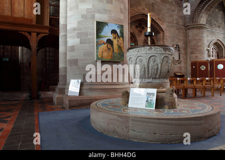 Auf einem runden Sockel gesetzt, die Stein geschnitzt Schriftart in Hereford Cathedral gegen ein Bild von einer Taufe hing eine riesige Spalte gesetzt. Stockfoto