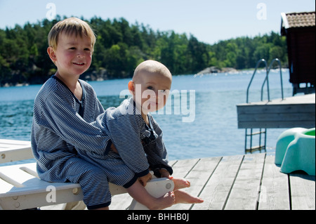 Bruder und Schwester auf einem Steg, Stockholmer Schären, Schweden. Stockfoto