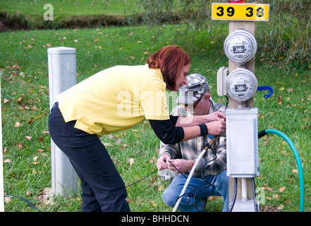 Mann und Campingplatz assistant hooking up Utilities in einem Recreational Vehicle Park. Virginggia, USA. Stockfoto
