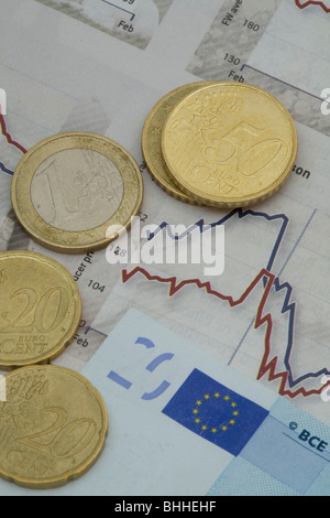 Euromünzen und Banknoten gegen eine Grafik Stockfoto