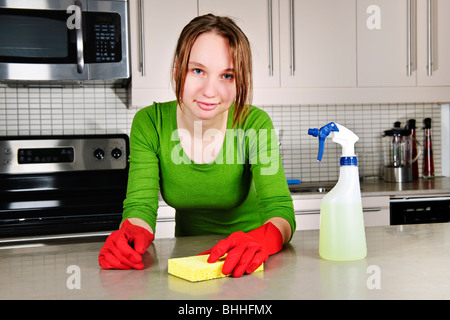 Junge Frau Küchenreinigung Aufgaben mit Gummihandschuhen zu tun Stockfoto