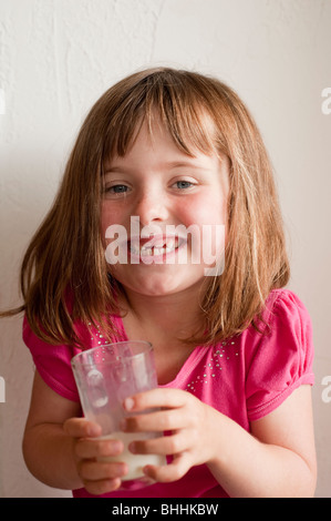 kleines Mädchen (5 Jahre alt), das fehlende vordere Zähne genießen Glas Milch Stockfoto