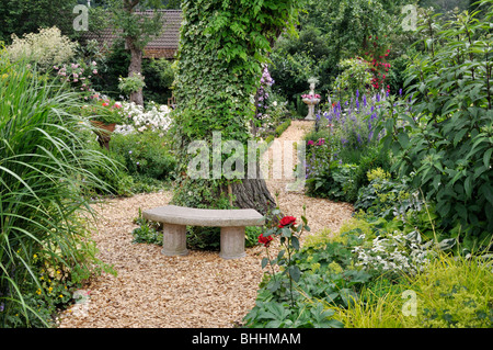 Kleine Steinbank in einem beständigen Garten. Design: Marianne und Detlef lüdke Stockfoto