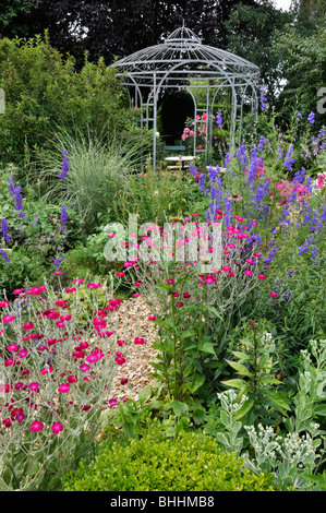 Krone Pink (Lupinus coronaria Syn. silene coronaria) und Rakete larkspurs ajacis (Konsolidierung) vor einem gartenpavillon. Design: Marianne und Stockfoto