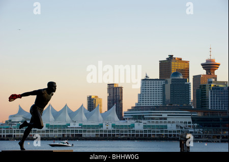 Statue des Olympischen Läufer Harry Jerome in Vancouver Stanley Park mit der Stadt Skyline im Hintergrund. Stockfoto