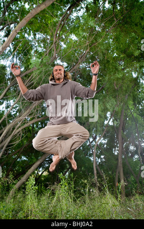 junger Mann im Auto mit Kopfhörer, Wald Stockfoto