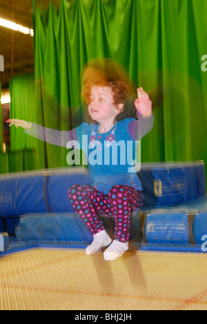 4 jährige Mädchen Trampolinspringen im Sportzentrum Schulferien Semesterhälfte, Alton, Hampshire, UK. Stockfoto