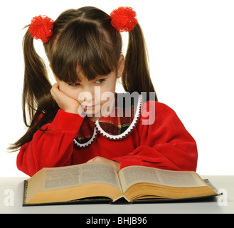 Das kleine Mädchen vor dem großen wissenschaftlichen Buch. Es ist isoliert auf weißem Hintergrund Stockfoto