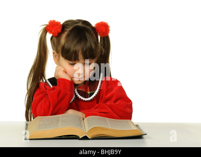 Das kleine Mädchen vor dem großen wissenschaftlichen Buch. Es ist isoliert auf weißem Hintergrund Stockfoto