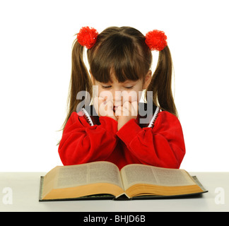 Das kleine Mädchen vor dem großen wissenschaftlichen Buch. Es ist isoliert auf weißem Hintergrund Stockfoto