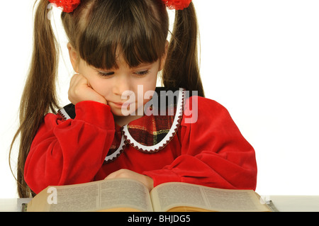 Das kleine Mädchen vor dem großen wissenschaftlichen Buch. Es ist isoliert auf weißem Hintergrund Stockfoto