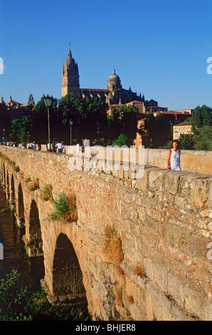 Spanische Frau zu Fuß über römische Brücke über den Fluss Tormes mit neuen Kathedrale von Salamanca, Spanien Stockfoto