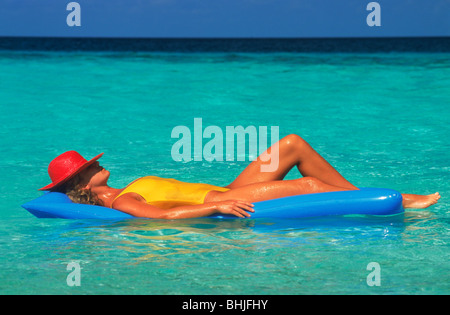 Frau auf Luftmatratze in ruhigen Gewässern wie schweben in einem Traum Stockfoto