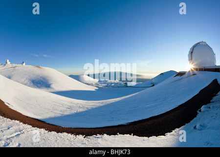 Blick vom Mauna Kea auf Mauna Loa als Sonne platzt hinter Keck Observatorium an einem Wintertag in Hawaii. Stockfoto