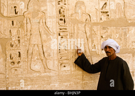 Tempelwächter zeigen Reliefs am Medinat Habu Tempel, Luxor, Ägypten Stockfoto