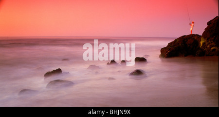 Fischer am felsigen Ufer bei Sonnenuntergang in Laguna Beach, Kalifornien Stockfoto