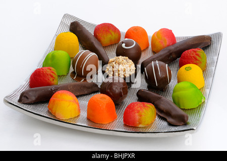 Schokoladentrüffel kandierte orange Schale und Marzipan Bonbons auf einem silbernen Tablett auf weiß Stockfoto