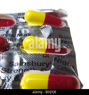 blaue, rote und gelbe Grippe Kapseln auf weißem Hintergrund Stockfoto